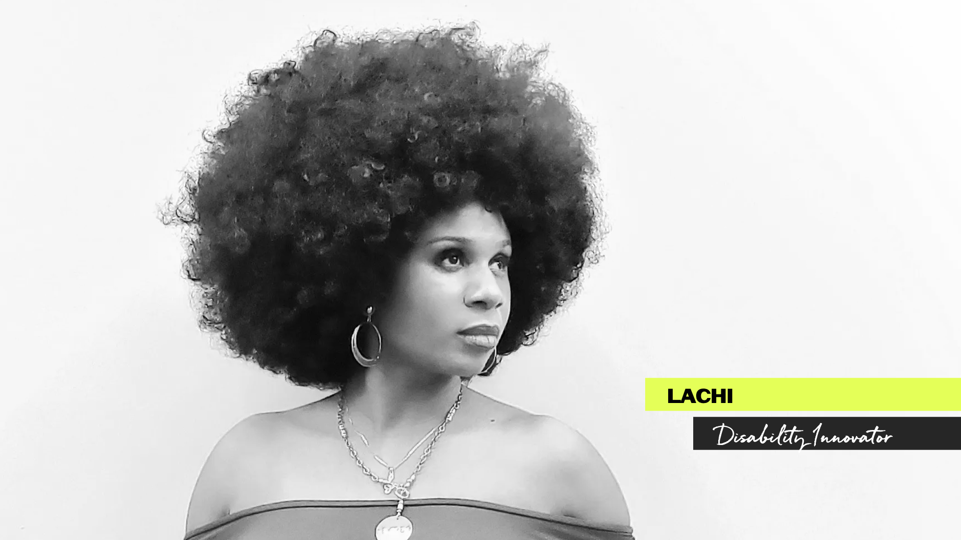 A black-and-white portrait of a person with a voluminous afro gazing confidently to the right against a plain white background. They wear hoop earrings, layered necklaces, and an off-the-shoulder top. The overlay text reads “LACHI, Disability Innovator” on neon yellow and black banners.
